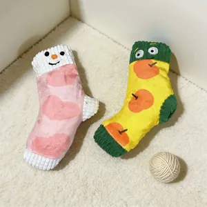 Vue détaillée de deux jouets en peluche pour chiens en forme de chaussettes colorées et mignonnes