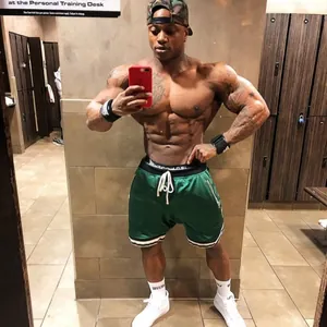 Vista dettagliata di pantaloncini sportivi in mesh verde indossati da un modello in palestra