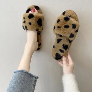 Nahaufnahme von niedlichen Leopard-Plüschhausschuhen mit weicher Sohle für Damen zu Hause