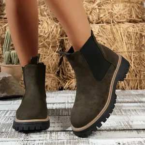 Detalle de primer plano de botas Chelsea de ante verde oscuro con suela de plataforma