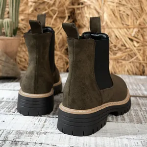 Detalle de botines Chelsea de ante verde oliva con suelas gruesas dentadas