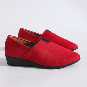 Side detail of women's vibrant red suede casual loafers with black wedge soles