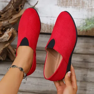 Close-up of red suede wedge slip-on shoes with an elegant pointed toe and casual design.