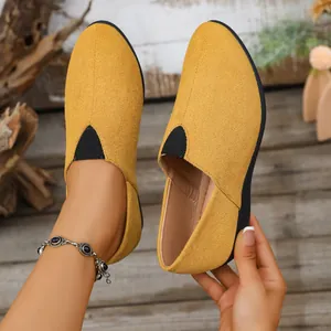 Close-up view of yellow suede wedge loafers with pointed toe and elastic side panels