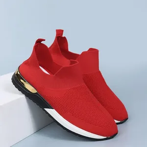 Détail de baskets en maille respirante rouge pour femmes avec un accent doré au talon.