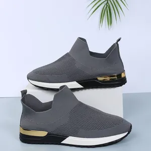 Gros plan sur des baskets grises respirantes en fly-knit avec détail doré au talon