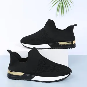 Vue latérale de baskets en maille respirante noire avec détails dorés au talon.