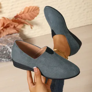 Close-up of blue-grey suede wedge loafers with slip-on design and pointed toe