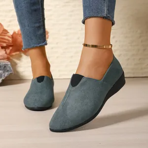 Close-up of the elegant teal suede texture and slip-on elastic detail of wedge loafers