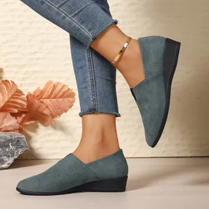 Detailed side view of women's blue-grey suede wedge loafers featuring a sleek pointed toe