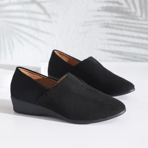 Detailed macro view of black pointed toe wedge loafers featuring a soft suede-like finish