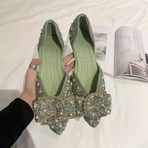 Detail van lichtgroene puntige ballerina's met fonkelende strik van strass en parels