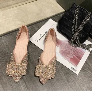 Detail van sprankelende strass en parel strik op champagne puntige ballerina's