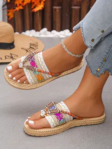 Detailansicht der flachen Boho-Zehentrenner mit bunter Stickerei und Perlenverzierung