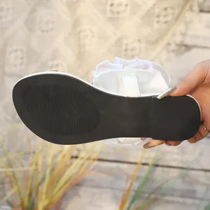 Vue détaillée de la sandale blanche à volants avec semelle noire antidérapante