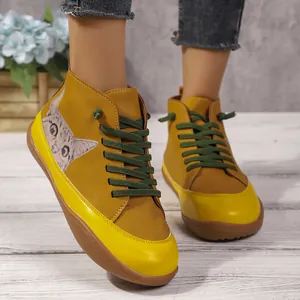 Detail van hoge platte damesschoenen met een schattige kattenprint en groene veters