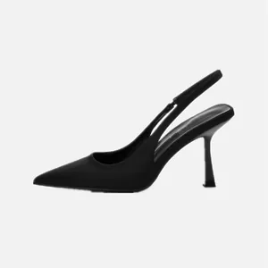 Detalle del perfil lateral de un zapato de salón destalonado negro clásico con punta.
