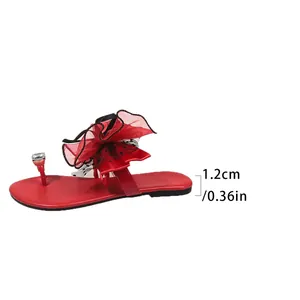 Vue détaillée des sandales plates rouges avec un nœud et talon de 1,2 cm de haut