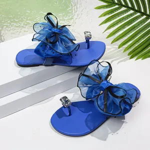 Sandales plates bleues élégantes avec un grand nœud en maille et des strass brillants
