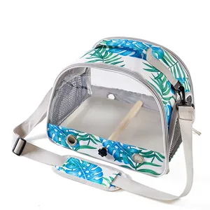 Detail view of portable bird carrier with blue monstera print and interior wooden perch