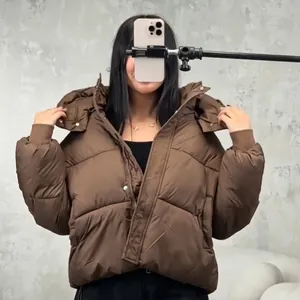 Detailed view of a women's brown hooded puffer jacket featuring a short and warm design.