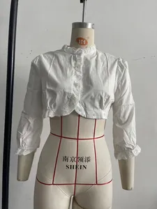 Dettaglio della camicia corta bianca vintage con bordi in pizzo e maniche a sbuffo
