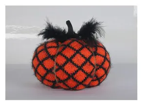 Detailed macro shot of a handmade orange and black knitted Halloween pumpkin decoration