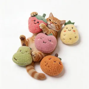 Schattige rode kat die speelt met kleurrijke pluche fruit kattenkruid speeltjes op wit