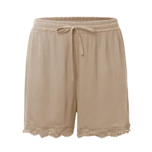 Gros plan sur un short décontracté beige avec bordure en dentelle et cordon de serrage.