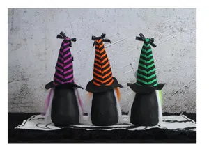 Detailed view of three mini Halloween gnomes wearing striped wizard hats in a row