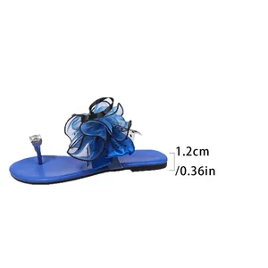 Détail latéral de sandale bleue à fleur montrant la hauteur du talon de 1,2 cm