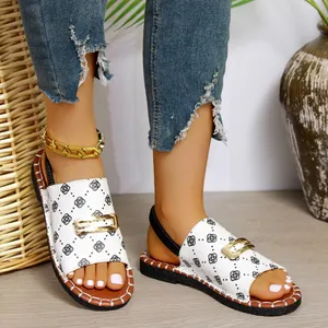 Vue détaillée de sandales plates pour femmes avec motif floral blanc et boucle dorée