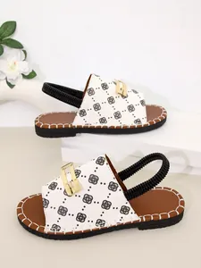 Vue détaillée de sandales plates pour femmes avec motif trèfle et boucle dorée chic