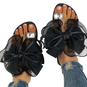 Sandales plates à bague d'orteil noires avec gros nœud en résille et strass pour femme