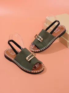 Détail de sandales plates vert olive pour femmes avec boucle dorée et surpiqûres
