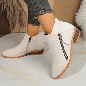 Side view of women's beige suede ankle boots with block heel and dual zippers