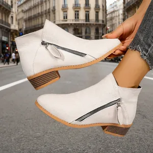 Close-up of women's light grey ankle boots with double side zippers and chunky heel