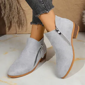 Detailed macro view of light grey suede ankle boots featuring stylish double side zippers
