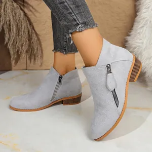 Detailed view of grey suede-like ankle boots featuring dual side zipper accents