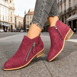 Close-up detail view of women's burgundy suede ankle boots with double side zippers