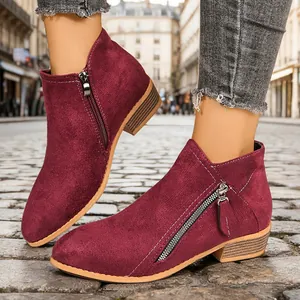 Detailed street view of burgundy suede chunky heel ankle boots with side zippers.