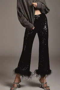 Close-up of black sequin trousers featuring elegant feather trim for evening wear