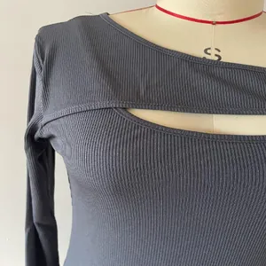Dettaglio maglia grigia a coste a maniche lunghe con elegante scollo asimmetrico