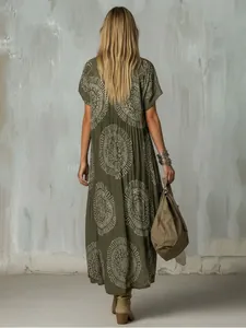 Vista trasera de un vestido midi bohemio verde oliva con estampados florales étnicos blancos y bolso