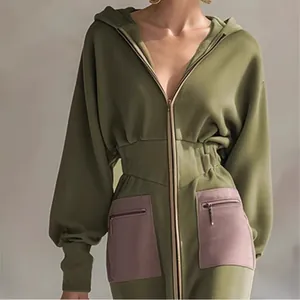Detail eines olivgrünen Kapuzen-Sweatkleids mit tailliertem Schnitt und lila Taschen.