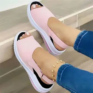 Nahaufnahme von rosa Plateau-Sandalen mit Peeptoe-Ausschnitt zu Jeans