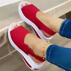 Nahaufnahme von roten Damen-Plateau-Sandalen mit dicken weißen Sohlen im Freien