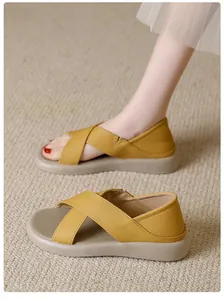 Close-up of yellow criss-cross leather sandals on textured carpet
