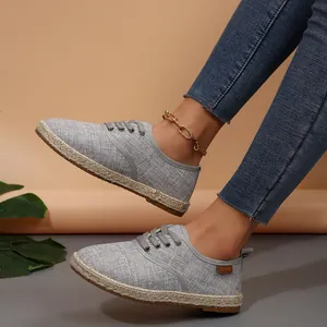 Close-up van grijze canvas espadrilles voor dames met casual denim.