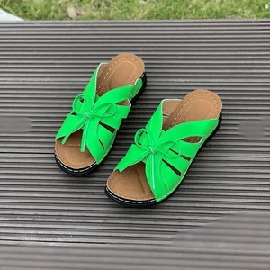 Detailed view of bright green peep-toe wedge slippers with hollow design and cute bow decoration